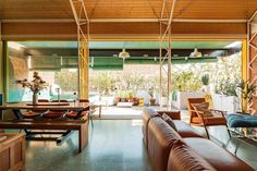 a living room filled with lots of furniture next to a wall mounted tv on top of a wooden ceiling