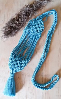 a blue crocheted tassel on top of a wooden table