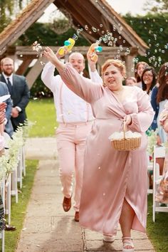 a man and woman are walking down the aisle with bubbles in front of their heads