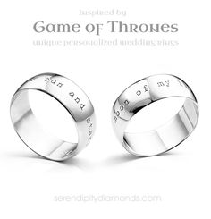 two wedding rings with names engraved on the inside and outside, one is white gold