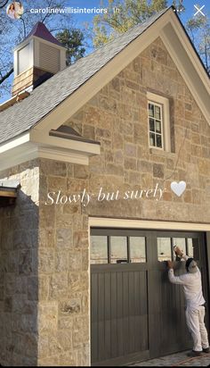 a man painting the side of a house with words above it that read slowly but surely