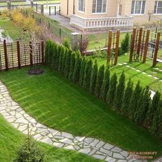 an aerial view of a garden with green grass and stone paths leading up to the building