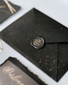 a black envelope with a waxed seal on it and some other items around it