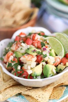 a white bowl filled with guacamole and salsa surrounded by tortilla chips