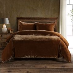 a bed with brown sheets and pillows in a room