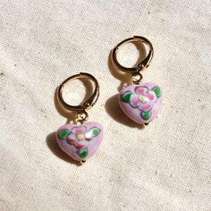 These earrings feature the prettiest hand painted vintage glass heart beads that were made in the Czech Republic in the 1960s attached to 14k gold plated hoops. Bead size: 9x12mm  Hoops: 12mm Please note there may be slight variances in the shape and design on the beads due to the hand painted, vintage nature. Vintage Dangle Heart Beads Jewelry, Vintage Dangle Jewelry With Heart Beads, Vintage Jewelry With Heart Beads And Dangle Shape, Handmade Heart-shaped Enamel Earrings, Pink Hand Painted Heart Jewelry, Vintage Handmade Heart Dangle Earrings, Retro Heart-shaped Earrings For Valentine's Day, Retro Heart Earrings For Valentine's Day, Vintage Handmade Dangle Heart Earrings