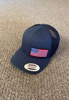 "This is a NEW United States of America Flag Embroidered Patch applied by hand to a high quality Yupoong or Richardson brand SnapBack Hat Yupoong Classic SnapBacks are 65% Polyester/35% Cotton, Structured, mid-profile, 3 1/2\" crown, six-panel Permacurv Visor adjustable plastic snapback closure 6 7/8\" to 7 1/2\" Richardson Hats are 60% cotton/40% polyester Structured, mid-profile, six-panel Pre-curved Visor adjustable plastic snapback closure 6 3/4\" -7 5/8\" Every Hat Design we offer is Create Patriotic Adjustable Hat With Curved Brim, Patriotic Adjustable Curved Brim Hat, Adjustable Patriotic Hat With Flat Bill, Trucker Hat With Curved Brim Made In Usa, Adjustable Trucker Hat Made In Usa, Adjustable Size Flat Brim Patriotic Hat, Adjustable Baseball Cap With American Flag And Curved Brim, Adjustable American Flag Baseball Cap With Curved Brim, Patriotic Adjustable Baseball Cap