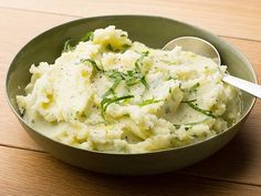 a bowl filled with mashed potatoes on top of a wooden table