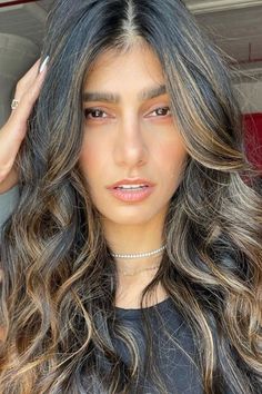 a close up of a person with long hair and wearing a ring on her finger