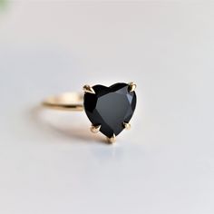 This handcrafted brightly polished ring features a heart-cut black onyx solitaire secured in a raised five-prong setting fashioned into an abstract Cathedral mounting. A round brilliant cut diamond nestles in an arc below the center, giving it a luxurious touch. A smooth band adds comfort to this enchanting ring. Dainty yet durable, elegant, and practical. This ring is designed to stack with straight or contour bands.  ---------------------- DETAIL ✦ Stone： Natural Black Onyx Shape： Heart Size：1 Black Heart Cut Jewelry For Wedding, Black Formal Jewelry With Tension Setting, Black Jewelry With Tension Setting For Formal Occasions, Formal Black Jewelry With Tension Setting, Black Ring With Tension Setting As Gift, Black Ring With Tension Setting For Gift, Black Jewelry With Tension Setting For Anniversary, Gift Black Ring With Tension Setting, Black Heart-shaped Gemstone Jewelry