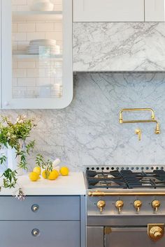 a stove top oven sitting inside of a kitchen next to a counter with yellow fruit on it