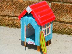 a toy house with surfboards on the ground