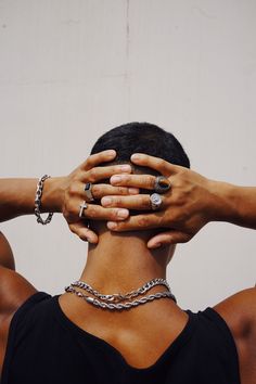 a man with his hands on his head and two other hands covering his face behind him