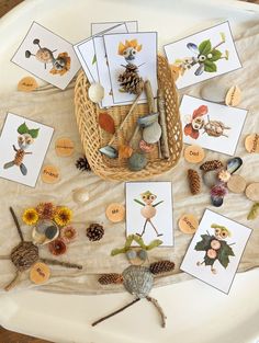 a table topped with lots of cards and pine cones on top of a white plate