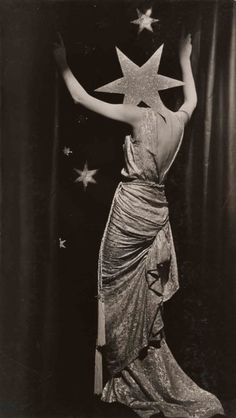 an old photo of a woman in a dress with stars on her head and arms