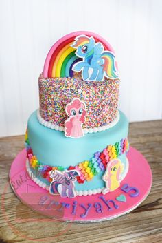 the cake is decorated with rainbows and unicorns