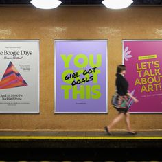 a woman walking past posters on the wall