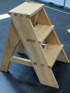 a wooden step stool sitting on top of a floor