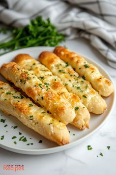 bread sticks with cheese and parsley on a white plate next to some green herbs