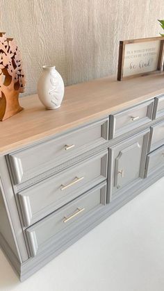 a white vase sitting on top of a gray dresser