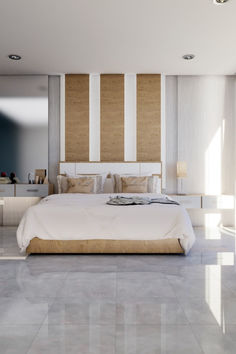 a large white bed sitting inside of a bedroom next to a wall mounted mirror on top of a wooden headboard