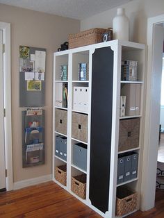 a white bookcase filled with lots of books on top of a hard wood floor