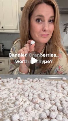 a woman standing in front of a baking pan filled with cookies and marshmallows