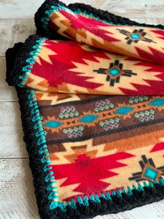 two pieces of colorful rugs sitting on top of a white wooden floor next to each other