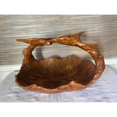 a wooden bowl sitting on top of a bed