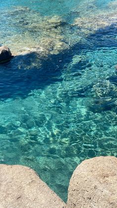 the water is crystal blue and clear with some rocks in front of it that look like they are floating