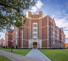 a large brick building with many windows on it's sides and a walkway leading to the front door