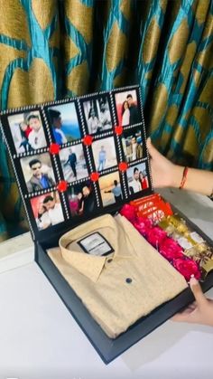 a woman is holding an open box with pictures on it and other items in front of her