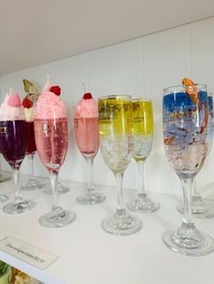 there are many different types of drinks on the table together in glasses with ice cream and strawberries