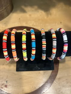 several bracelets are lined up on a black stand