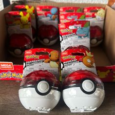 two poke ball toys sitting next to each other on top of a wooden table in front of boxes