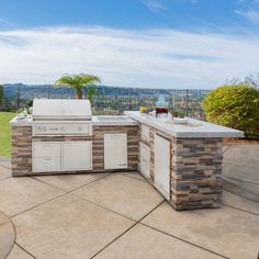 an outdoor kitchen with grill, sink and table