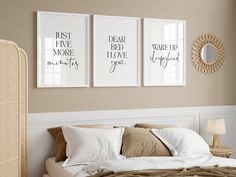 a bed with pillows and two framed pictures on the wall