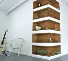 a guitar is sitting in front of a book shelf