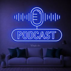 a white couch sitting under a neon sign in front of a blue wall with a microphone on it