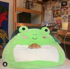 a green frog pillow sitting on top of a table