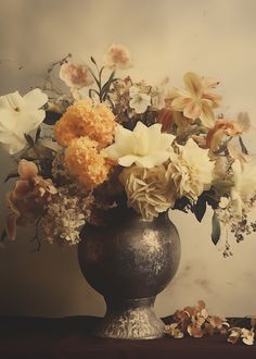 a vase filled with lots of flowers sitting on top of a wooden table next to a wall