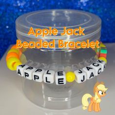 "This Apple Jack Beaded Bracelet is cute and a features the character from \"My Little Pony.\" This bracelet is handmade with love and creativity." Novelty Bracelets With Letter Beads, Cute Crafting Bracelets With Letter Beads, Customized Novelty Friendship Bracelets, Cute Letter Beads Bracelets For Crafting, Handmade Novelty Stretch Bracelet With Round Beads, Handmade Adjustable Novelty Name Bracelet, Handmade Novelty Beaded Bracelets For Birthday, Handmade Novelty Bracelets For Birthday, Handmade Themed Beaded Bracelets For Birthday