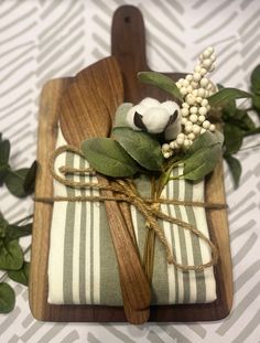 a small wooden tray with napkins wrapped in green and white striped fabric, tied with twine