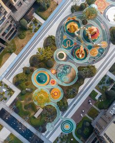 an aerial view of a park with lots of trees and colorful circles on the ground