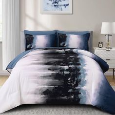 a bed with blue and white comforters in a room