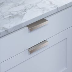 a marble counter top with two drawers and one drawer closed to show the same item