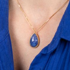 This magnificent Tanzanite is a perfect statement necklace with its bold navy blue color and striking faceted surface. This captivating gemstone is set in a handmade gold setting accented with braided gold. It’s strung on an 18k yellow gold chain. One of a kind. Technical Details Metal: 18k yellow goldTanzanite: 12.77 cts. Pendant Size (not including bail): 21mm x 14mmChain: can be worn at 16" and 18"Closure: lobster claspHandmade in New YorkStyle # N-3164-TA Gold Necklaces With Sapphire And Gemstone Accents, Gold Necklaces With Sapphire Briolette, Gold Sapphire Gemstone Necklace, Gold Necklaces With Briolette Sapphire, Classic Oval Tanzanite Necklaces, Gold Teardrop Sapphire Necklace, Elegant Gold Tanzanite Necklace, Luxury Tanzanite Gold Necklaces, Briolette Tanzanite Necklace For Gift