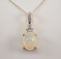 Yellow Gold Diamond and Opal Pendant Necklace. The Necklace is set with one Oval Opal Cabochon in the center.  This Opal measures 9 X 7 mm and weighs 1 1/4 carat.  There are eight Round Brilliant Diamonds set in this pendant. These diamonds are H color, SI/I1 clarity and weigh a total of .05 carat.  The pendant is 10K Yellow Gold and comes with an 18" 10K Yellow Gold chain and together weigh 1.5 grams.  The pendant measures 19 mm in length.  This necklace will be accompanied by an appraisal with the retail replacement value of $1,245.00.  I will ship this necklace promptly in a gift box. October Gemstone, Opal Pendant Necklace, Gold Choker, Yellow Gold Chain, Diamond Pendant Necklace, Opal Pendants, Fine Jewellery Necklace, October Birth Stone, Brilliant Diamond