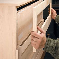 a man is working on some drawers in a cabinet that he made from plywood