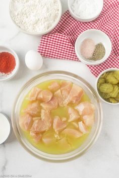 ingredients to make chicken soup laid out on a white counter top with red and white checkered towels